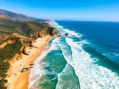 Surfers riding waves at Pismo Beach under blue sky.