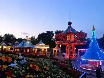 Colorful rides and flowers at Tivoli Gardens in evening light.