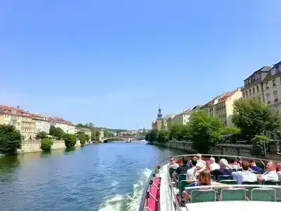 Scenic river cruise with historic buildings and greenery.