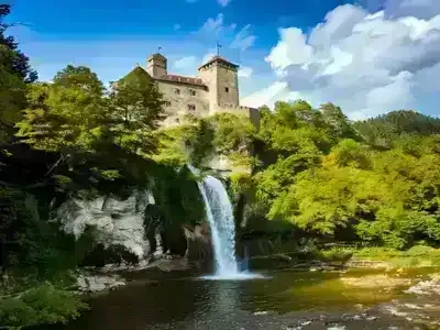 Niedzica Waterfall and castle with a blue cloudy sky