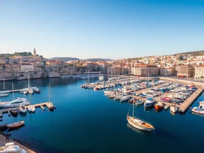 Coastal view of Marseille with boats and historic buildings.