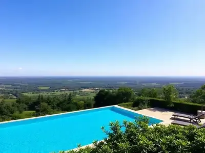 Infinity pool with scenic French countryside view.