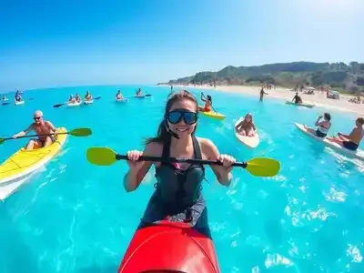 Families enjoying water sports activities at a Greek beach.