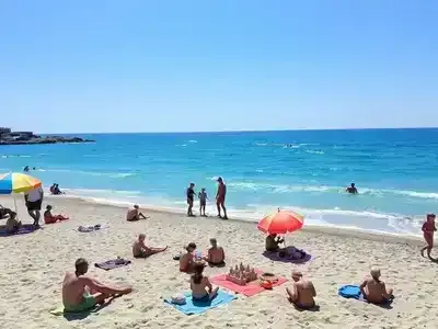 Families enjoying a sunny beach day in Italy.