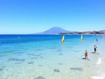 Catania coastline with water sports and clear blue waters.