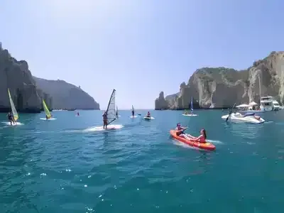 People enjoying water sports in a sunny Italian coastal setting.