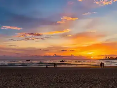 Couples enjoying a sunset stroll on Lagos beach.