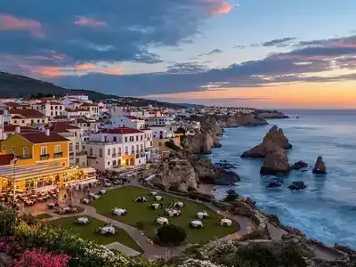 Sunset over coastal village with vivid dining and picnic scenes.