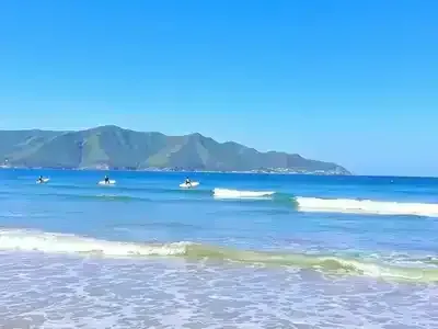 Surfers enjoying gentle waves at Somo beach.