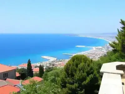 Coastal view of Izmir with clear skies and greenery.