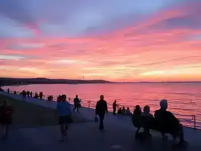 Coastal sunset in Izmir with people enjoying leisure.